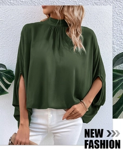 Detail of dark green mock neck blouse with pleated collar and chic split cape sleeves