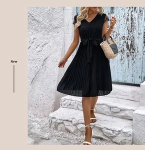 Detail of V-neck summer dress featuring black lace sleeves and pleated skirt finish