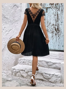 Detail of elegant black pleated dress with floral lace back and fine waist belt