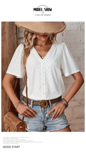 Detail of white V-neck short sleeve shirt with eyelet embroidery and puffed sleeves