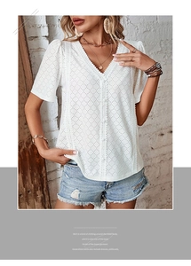 Close-up of white V-neck top featuring hollow embroidery, lace trim, and button details