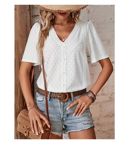 Detail of white eyelet V-neck shirt featuring lace trim and button-front design