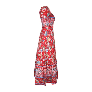 Detail of bohemian red floral maxi dress showing smocked waist and layered wave hemline