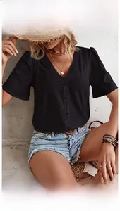 Detail of black V-neck shirt featuring intricate eyelet embroidery and scalloped lace trim