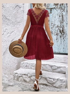 Macro view of elegant wine red pleated dress featuring intricate floral lace on deep V-back