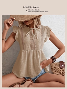 Details der beigen ärmellosen Bluse mit Spitzenbesatz, Rüschenärmeln und Punktstruktur