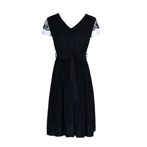 Detail of elegant V-neck dress featuring delicate lace sleeves and a pleated black skirt