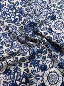 Detail of smocked waist trousers showing blue mandala floral print on cotton linen fabric