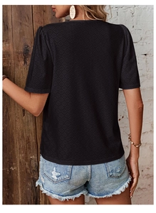 Close-up back view of black V-neck t-shirt featuring intricate circular eyelet lace texture