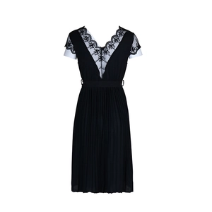Detail of the deep V-neckline with delicate black lace embroidery and pleated skirt texture