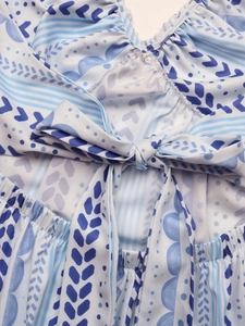 Détail de la robe à imprimé géométrique bleu et blanc avec nœud papillon au dos