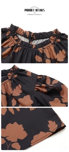 Detail of ruffled elastic neckline and brown leaf print on a black summer blouse