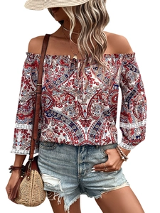 Detail of off-shoulder blouse featuring paisley print and delicate white lace cuffs