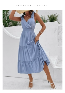 Detail of light blue backless summer dress featuring tiered ruffle hem and bow straps
