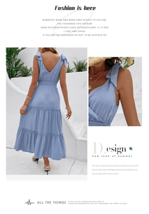 Detail of light blue backless summer dress with shoulder bows and tiered ruffle skirt
