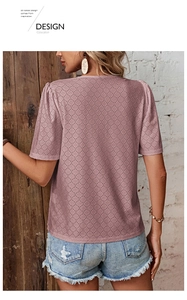 Detail of woman's pink short sleeve top featuring lace hollow texture and bubble sleeves