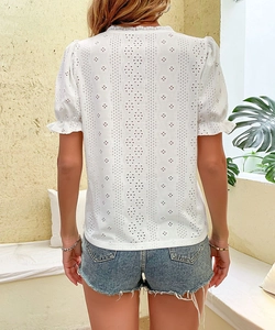 Detailed back view of white lace hollow-out top with puff sleeves and ruffle cuffs
