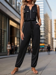Close-up of black sleeveless jumpsuit showing silver zipper and drawstring waist detail