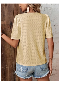Detailed back view of a beige V-neck top with intricate lace embroidery and hollow-out texture