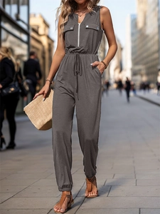 Detail of dark gray sleeveless jumpsuit showing zip neckline and drawstring waist