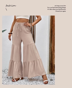 Detail showing high-waist tiered flared trousers with elastic drawstring in light khaki