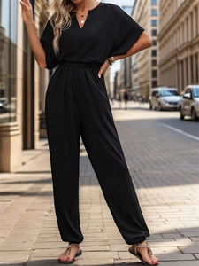 Detail of short-sleeve black jumpsuit with V-neckline and elastic waist for women