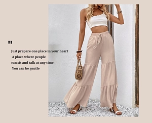 Detail of high waisted tiered wide leg trousers featuring drawstring elastic waist