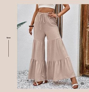 Detail of high waist tiered flare trousers with textured fabric and drawstring waist