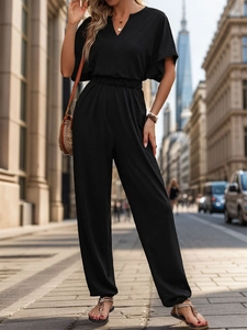 Detail of a casual black short sleeve jumpsuit with V-neck and elastic waist design