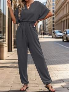 Detail view of dark grey summer jumpsuit with batwing sleeves and cinched waist design
