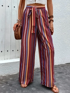 Detail of high waisted wide leg trousers with colorful geometric ethnic print and waist tie