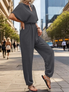 Detail of dark grey jumpsuit featuring elastic waist and high-quality draped fabric