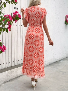 Detail of the ruffle hem on a bohemian summer maxi dress with orange geometric floral print