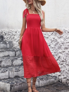 Detail of red sleeveless midi dress showing lace patchwork hem and elegant waistline