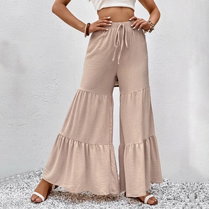 High waisted cream flared trousers with elastic drawstring waist and tiered ruffle design