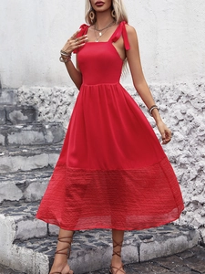 Detail of red sleeveless midi dress with elegant bow straps and pleated texture hem