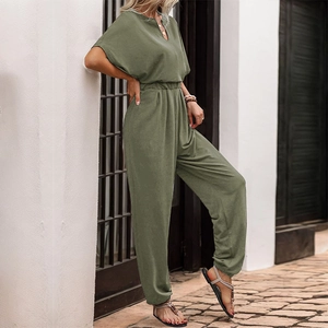 Detail of army green V-neck jumpsuit with button accents and elastic waist design