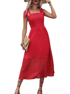 Detail of red sleeveless midi dress with bow shoulder straps and pleated hem texture