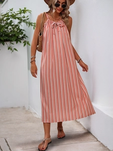 Détail d'une robe d'été rayée rose et blanc avec décolleté licou et nœud décoratif chic