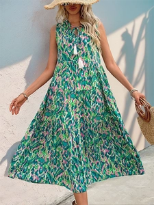 Detail of bohemian tiered dress with abstract print and tasseled neckline ties