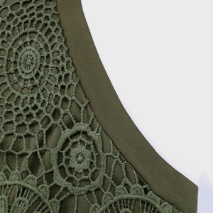 Détail d'un haut vert olive montrant la dentelle au crochet et la texture du tissu gaufré