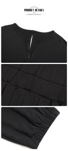 Detail of black knit romper featuring a keyhole button back and textured ruched fabric