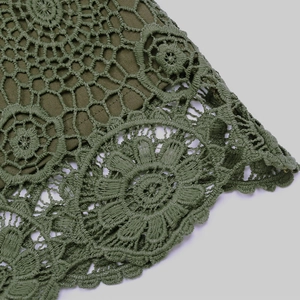 Gros plan sur le tissu dentelle vert olive avec des motifs de crochet circulaires fins