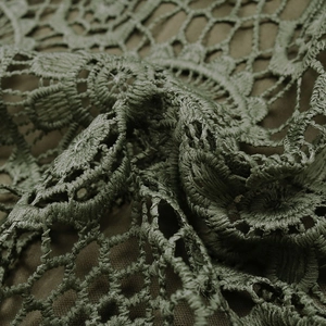 Détail de la texture en crochet vert foncé avec motifs de dentelle ajourés délicats