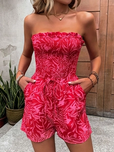 Detail of smocked strapless bodice and vibrant red leaf print on bohemian romper