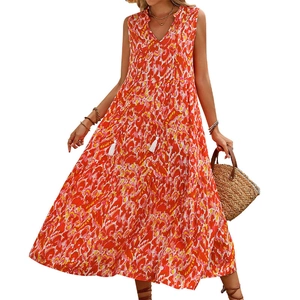 Front view of tiered sleeveless maxi dress with orange abstract print and tassel v-neckline