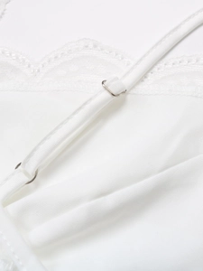 Détail de la bretelle réglable avec boucle argentée et bordure en dentelle blanche