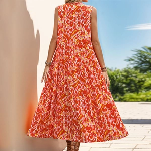 Detail of bohemian sleeveless maxi dress with orange abstract prints and layered cake hem