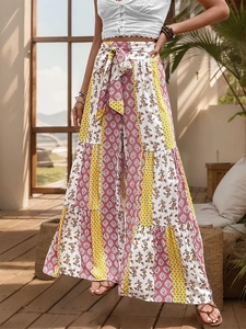 Detail of high waisted bohemian wide leg trousers with colorful floral print and tie waist
