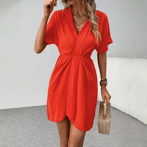 Detail of red V-neck summer dress with waist pleats and soft woven fabric texture